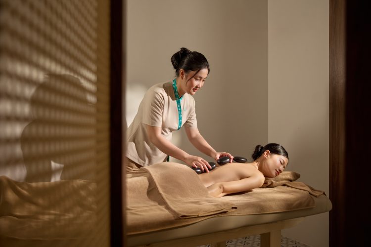 Guest enjoying a hot stone massage therapy for deep muscle relaxation at Serene Spa Phu Quoc.